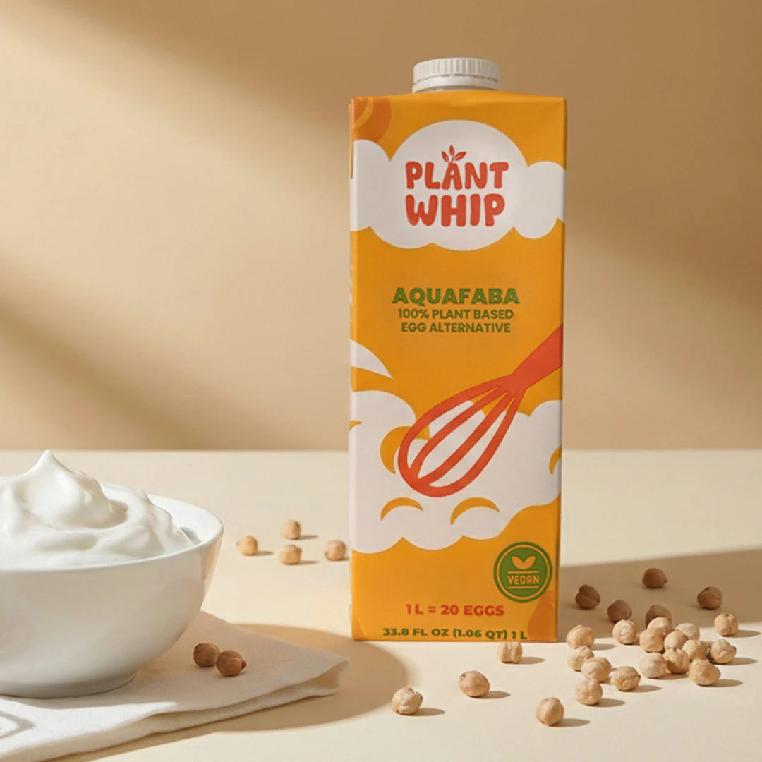 PlantWhip Liquid Aqafaba carton with dried chickpeas scattered around and a bowl of whipped aquafaba.