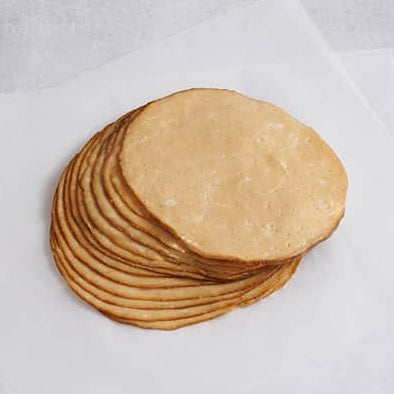 A stack of sliced Tofurky Roasted Turk'y Deli Slices on white parchment paper