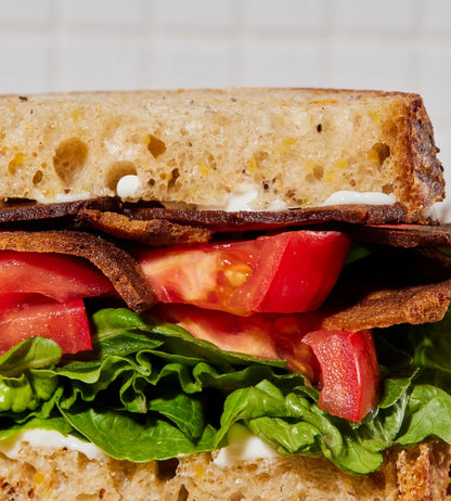 A closeup of a BLT sandwich with Prime Roots bacon, tomato, lettuce, and mayonnaise.